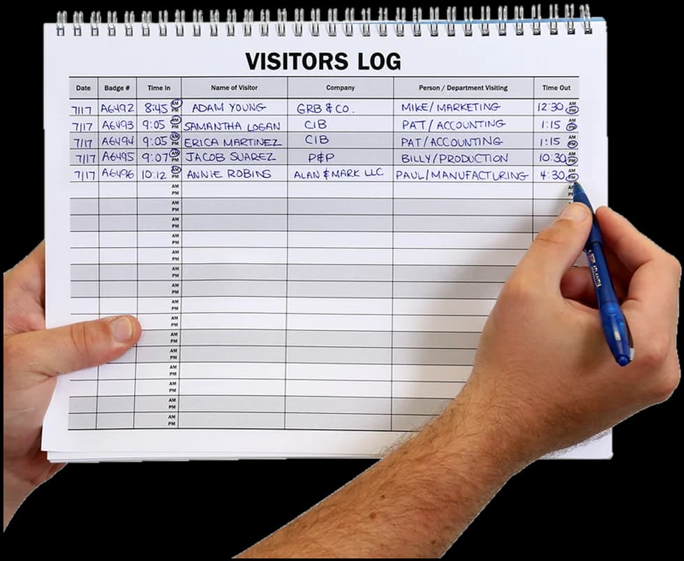 A paper visitors log book being filled in by hand with date, badge number, time in, visitor name, company and time out