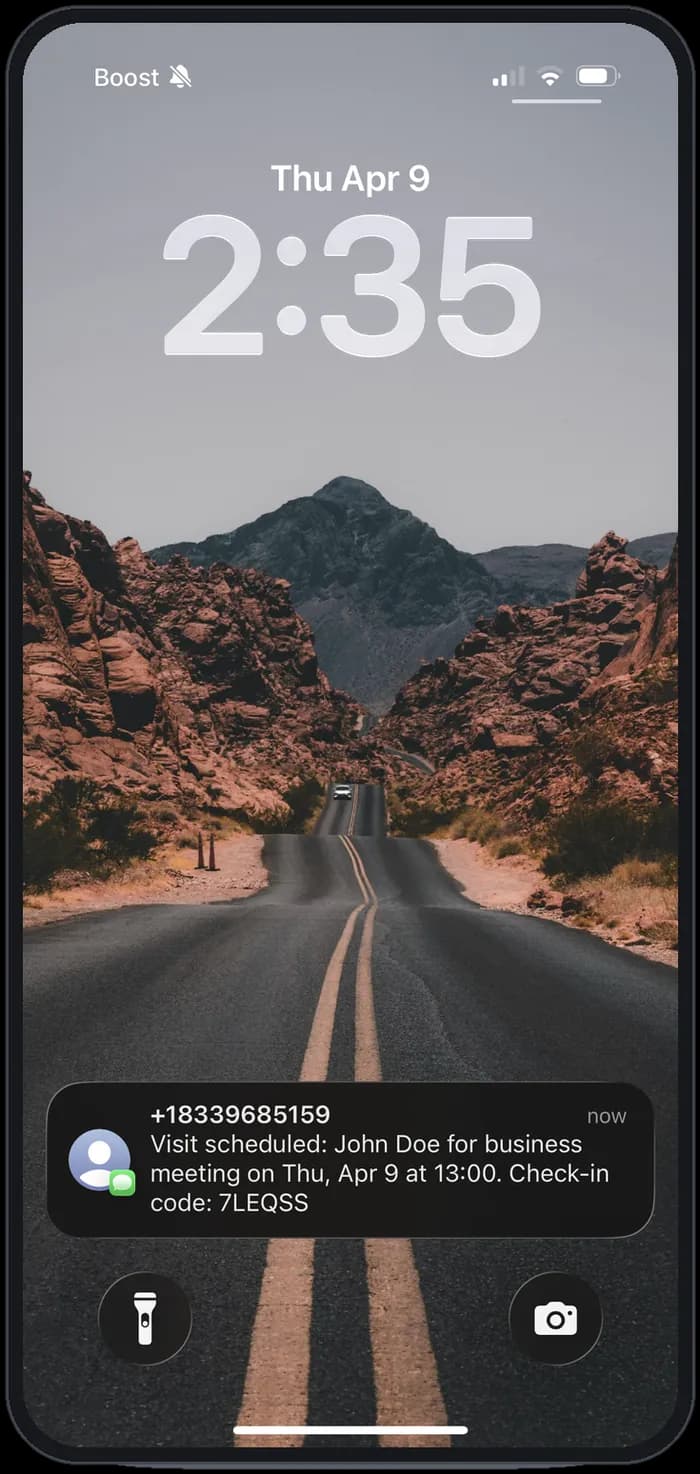 Phone lock screen showing a text message with the visit details and check-in code